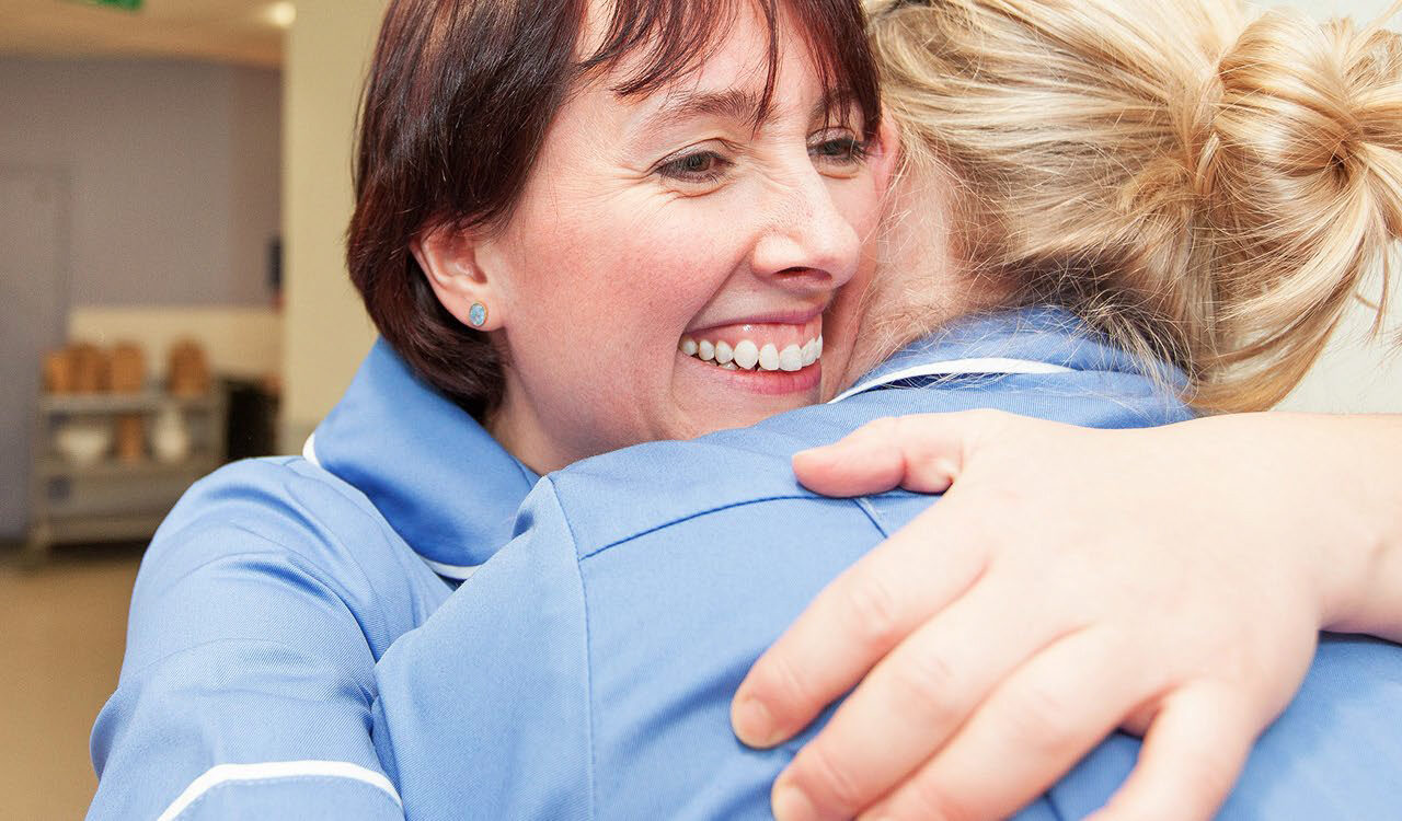 Two nurses hugging